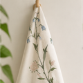 Kökshandduk i bomull som hänger på en krok, med Julia Sundby af Robsons blomster- och fågelmönster